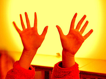 Foto von Kinderhänden vor einer Videoleinwand